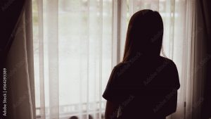 Девушка подросток смотрит в окно